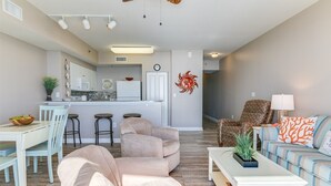 Un salon moderne avec un canapé, une table basse et un fauteuil à motifs.