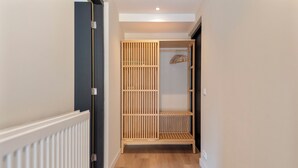 A hallway with a wooden wardrobe, a radiator, and a hanging rack. - Blissea - Comfortable stay, top location (Zandvoort)