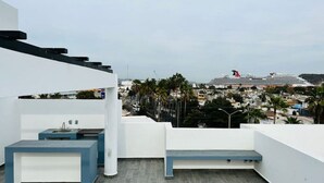 A rooftop terrace with a modern design, featuring a seating area and a sink. - Aleman Apartments  (Mazatlán)
