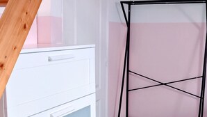 A room with a white dresser, a black metal shelf, and a wooden staircase. - LES COMBLES DE PIERRE 6, Bollaert, Fac, 1pers, parking (Lens)