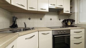 Een moderne keuken met witte kasten, een roestvrijstalen spoelbak en een inbouwoven.