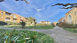 A pathway leading to a residential building with a clear sky.