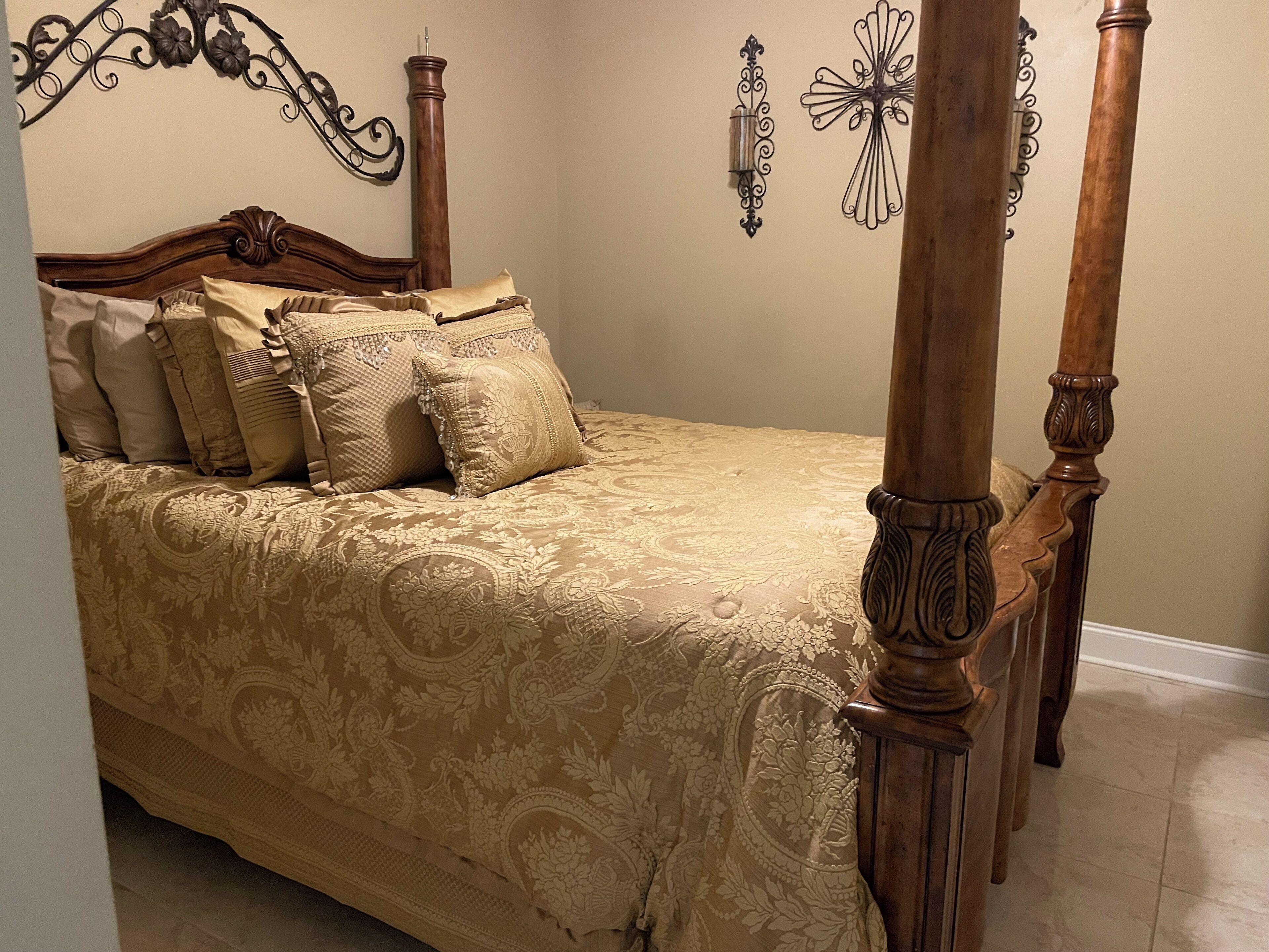 Un lit à baldaquin avec une couvre-lit à motifs floraux et des coussins assortis.