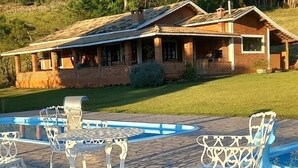 A house with a swimming pool and patio furniture.