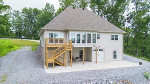 Une maison à deux étages avec un porche abrité et un escalier en bois.