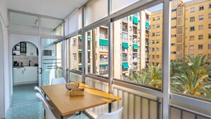 A modern apartment with a balcony, a dining area with a table and chairs, and a view of neighboring buildings. - Inftour Garvimar Apartamento (Calp)