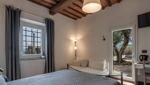 Une chambre à coucher avec un lit, un bureau, une fenêtre avec des rideaux, une lampe et une vue sur l’extérieur.