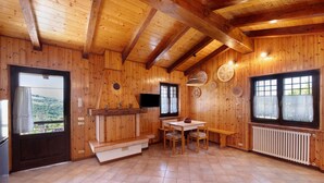Un interior de madera con una zona de cocina, una mesa de comedor y un banco.