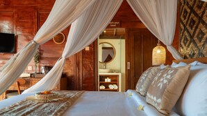 A bedroom with a bed, canopy, bedside table, and a mirror. - Tiara Villa Ubud by Dhananjaya Hospitality (Sebatu)