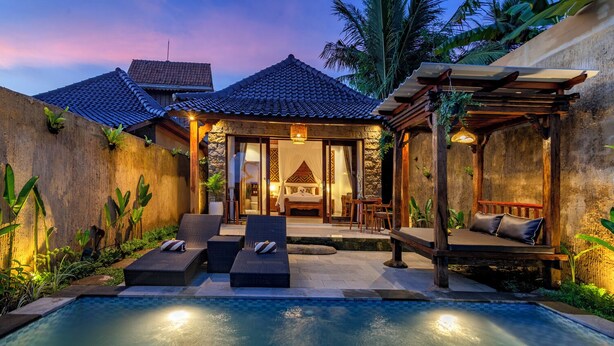 A poolside area with lounge chairs, a covered seating area, and a bedroom with a bed and curtains. - Tiara Villa Ubud by Dhananjaya Hospitality (Sebatu)
