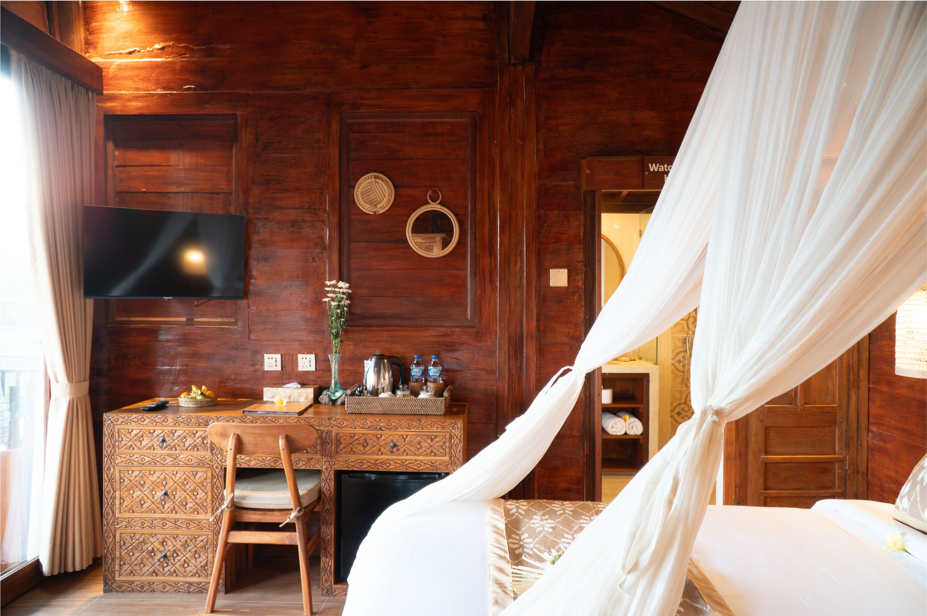 A wooden room with a bed, a desk, a TV, and a wardrobe.