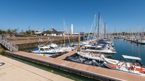 A marina with boats docked, a dock with a ramp, and a building in the background. - Bâbord, quiet artisan area, near port & beach, wifi, parking, towels & cleaning not included (Arzon)