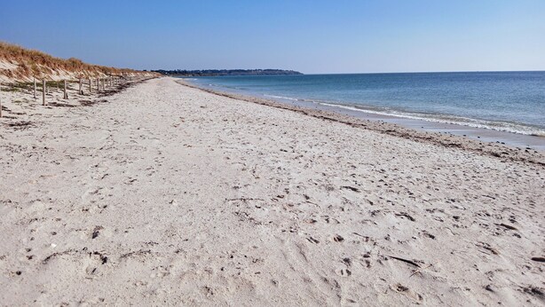 A wide sandy beach with a clear sky and calm sea. - Bâbord, quiet artisan area, near port & beach, wifi, parking, towels & cleaning not included (Arzon)