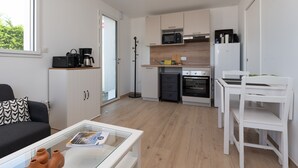 A compact living space with a kitchenette, a sofa, a coffee table, and a dining area. - Bâbord, quiet artisan area, near port & beach, wifi, parking, towels & cleaning not included (Arzon)