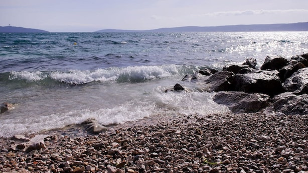 A rocky shoreline with waves crashing onto the pebbles. - Picturesque House in Kaštela Old Town Near Beach and Local Amenities (Kastela)