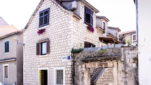 A stone building with a sign for 'APARTMANI' and 'FRIZERSKI SALON'. - Picturesque House in Kaštela Old Town Near Beach and Local Amenities (Kastela)