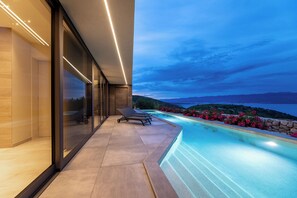 A modern outdoor pool area with a view of the sea and mountains. - Villa Panoramica with heated pool and sauna (Kvarner - Vrbnik) (Vrbnik)