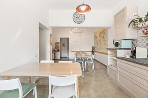 Une cuisine moderne avec un coin repas, une décoration murale représentant un globe terrestre et un four à micro-ondes.