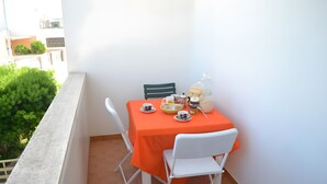 Un balcón con una mesa para dos, sillas y vistas a la vegetación.
