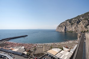 Un hotel frente al mar con estacionamiento, sombrillas de playa y vistas al acantilado.