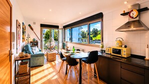 A modern kitchen with a dining area, large windows, and a view of the outdoors. - Las Xanas - Views, Swimming Pool and Terrace in LLanes (Llanes)