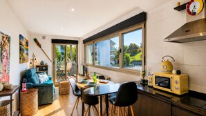 A modern kitchen with a dining area, large windows, and a yellow retro toaster. - Las Xanas - Views, Swimming Pool and Terrace in LLanes (Llanes)