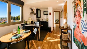 A modern kitchen with a dining area, a view through large windows, and a painting on the wall. - Las Xanas - Views, Swimming Pool and Terrace in LLanes (Llanes)