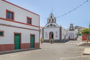 A street with buildings, including a church with a bell tower and a clock. - 'Casa Cueva' with Mountain View, Private Terrace and Private Garden (Juncalillo)