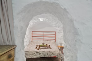 A bedroom with a zebra-patterned bedspread, a wooden bedside table, and a red metal headboard. - 'Casa Cueva' with Mountain View, Private Terrace and Private Garden (Juncalillo)