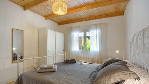 A bedroom with a bed, a mirror, a window with curtains, and a wooden ceiling. - Holiday Home 'Picarus' with Private Terrace, Wi-Fi, Air Conditioning & Heating (tacoronte)