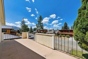 A residential area with a balcony, a fence, and houses in the background.
