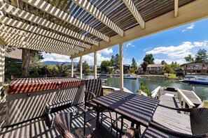 A covered outdoor seating area with a view of a lake and boats. - Waterfront Family Home with Private Boat Dock (South Lake Tahoe)