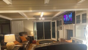 Una sala de estar con un sofá de cuero, una mesa de centro, un televisor y una chimenea.
