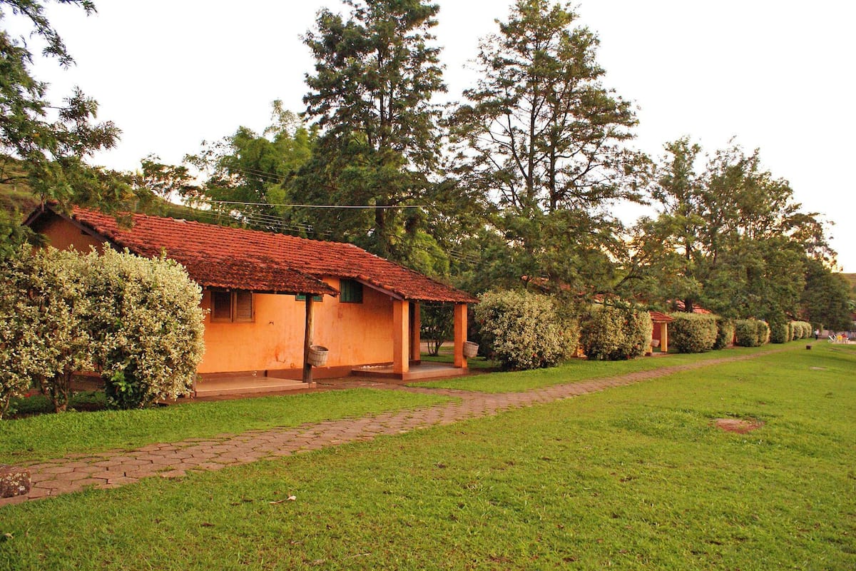 Una hilera de pequeñas casas con techo naranja, senderos de ladrillo y céspedes verdes.