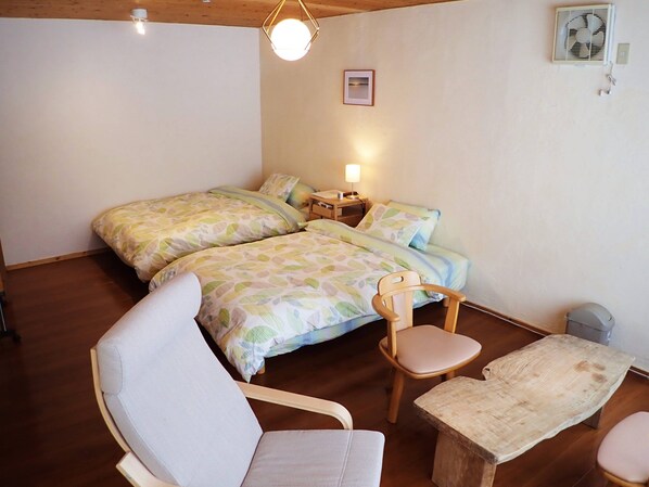 A bedroom with two beds, a wooden chair, a small table, and a bedside lamp. - Quiet Forest Retreat with Views of Mount Yotei – 3 bedrooms, 10 minutes from Niseko (ニセコ町)