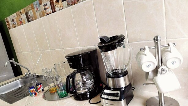 En køkkenbordplade med kaffemaskine, blender og et glas