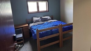 A bedroom with a single bed, a nightstand, a window, and a ceiling light. - Apartment Centrally Located (Plymouth)