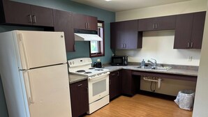 A compact kitchen with a refrigerator, stove, microwave, and sink. - Apartment Centrally Located (Plymouth)
