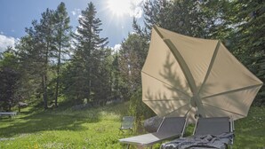 An outdoor camping area with a large canopy tent, two camping chairs, and a bench. - Waldblick by Interhome (Seefeld in Tirol)