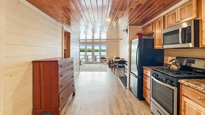 A kitchen with wooden cabinets, a refrigerator, a stove, and a microwave. - The Crooked Nook (Direct Lake Access) (Rockwood)