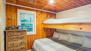 A wooden-paneled room with a bunk bed, a dresser with drawers, and a framed picture on the wall. - The Crooked Nook (Direct Lake Access) (Rockwood)