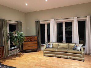 A living room with a sofa, a wooden cabinet, and a potted plant.