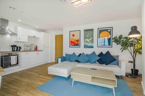 Ein modernes Wohnzimmer mit einer Couch, einem Couchtisch und Kunstwerken an der Wand.