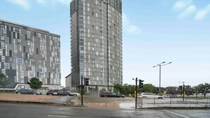 Un immeuble moderne de grande hauteur, doté d’une façade à motifs géométriques et d’une partie supérieure incurvée.