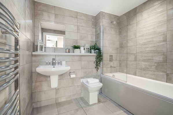 Une salle de bain moderne avec un lavabo, des toilettes et une baignoire.