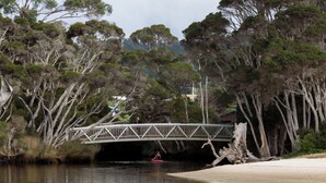 A river with a wooden bridge, a kayak, and a sandy beach. - Family Comfort in the Stunning Sisters Beach (Sisters Beach)