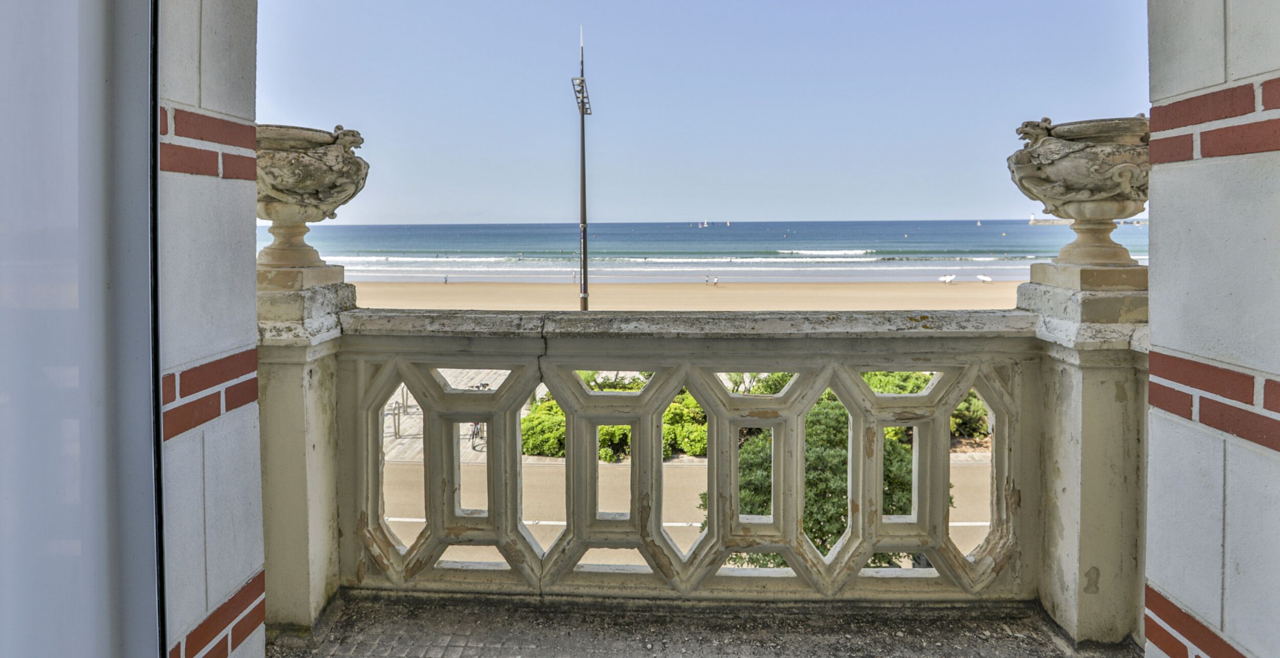 Un balcon avec vue sur la plage et l’océan.