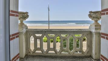 Un balcon avec vue sur la plage et l’océan.