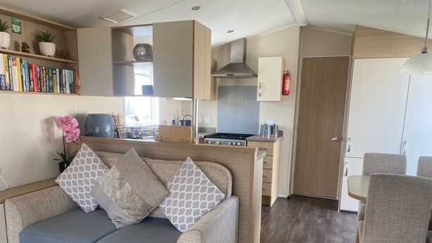 Un espace de vie compact comprenant un canapé, une table à manger et un coin cuisine.
