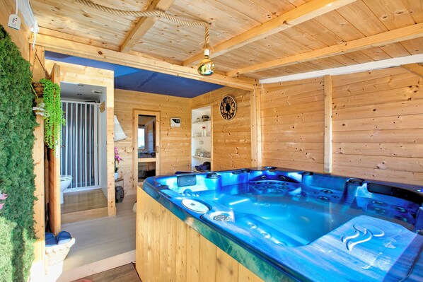 A wooden cabin with a hot tub, wooden walls, and a ceiling with exposed beams. - Casa Fra Gli Ulivi - Acciuga Blu, Ameglia, Italy (Ameglia)
